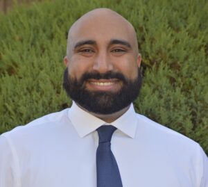 Photo from the torso up of Arman Sidhu, an educator dressed in a white shirt with a blue tie, who is part of ExcelinEd's first Education Policy Resident program