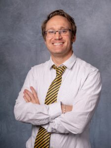 Photo from the torso up of Arman Sidhu, adressed in a white shirt with a blue tie, who is part of ExcelinEd's first Education Policy Resident program